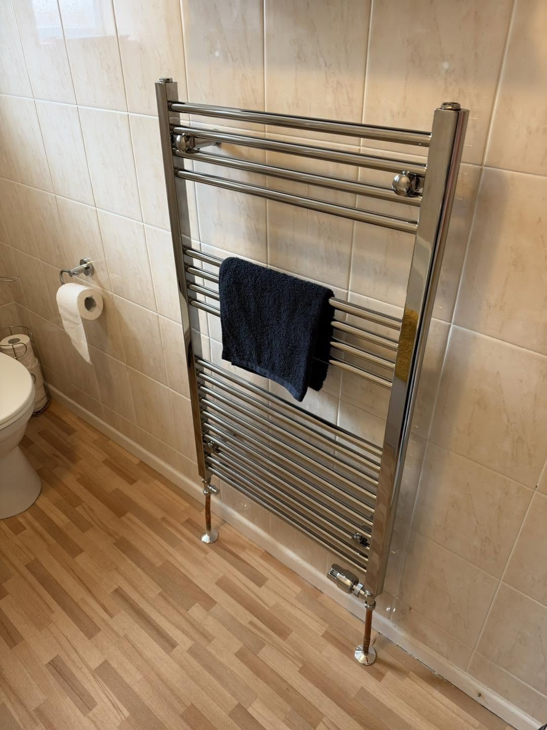 Chrome towel rail in a tiled bathroom