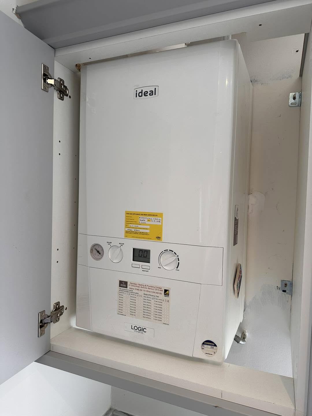 White Ideal boiler in a cupboard with the door open