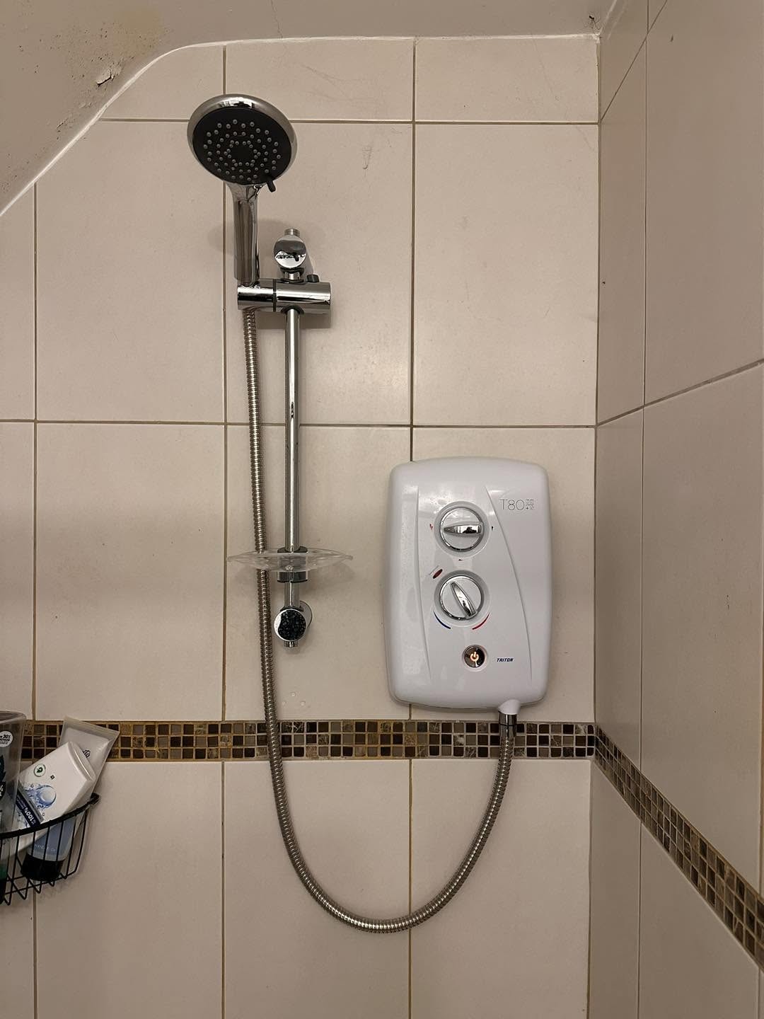 Electric shower on a riser rail over a tiled bath