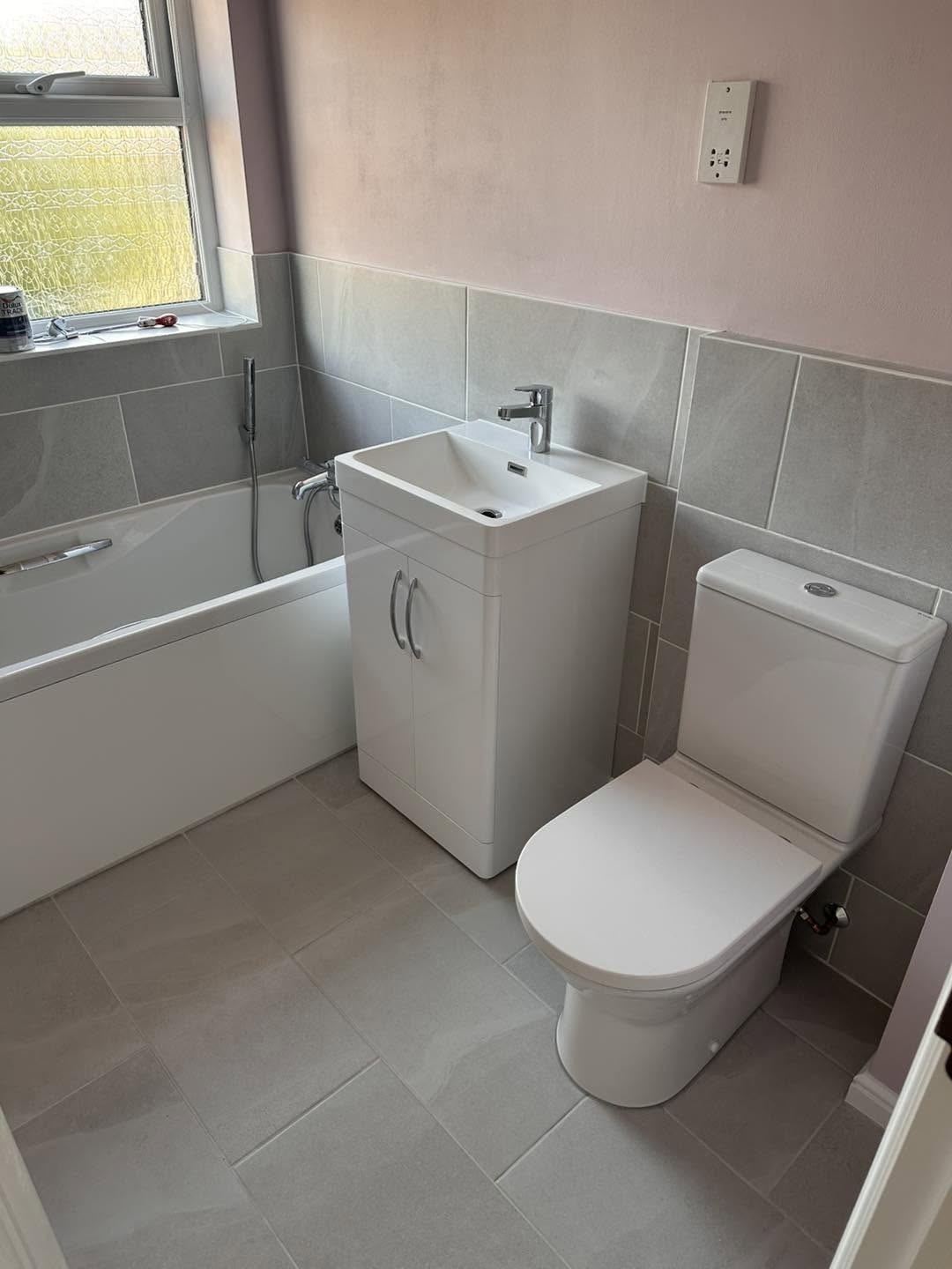 White vanity unit and toilet with grey wall tiles